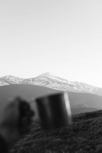 旅游杯子在人的手在山的背景上