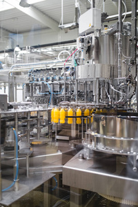 工业工厂室内和机械。用于加工和装瓶汽水和橙汁瓶的机器人生产线。选择性对焦。野外深度短