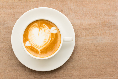 杯拿铁咖啡咖啡用木制的背景上绘制的心
