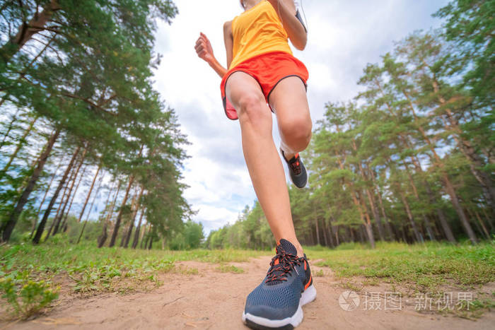 运动员在公园跑步的特写镜头.健身的女人慢跑在户外.