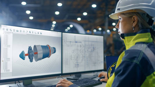 重工业工厂内的女工业工程师使用 Cad 程序在3d 涡轮发动机项目中的个人电脑上工作