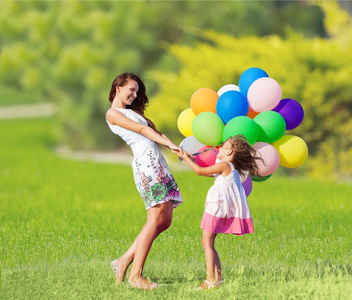 母亲带着女儿控股五颜六色的气球