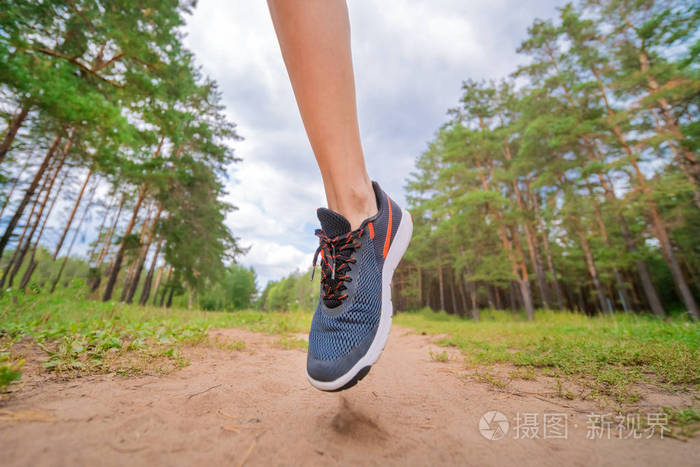 运动员在公园跑步的特写镜头.健身的女人慢跑在户外.