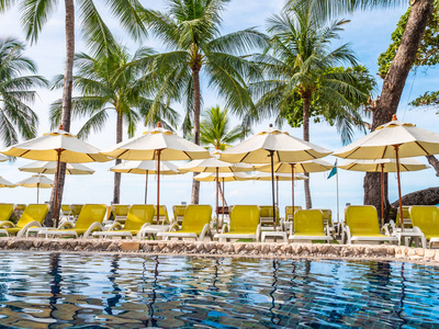 雨伞和椅子周围的豪华室外游泳池在酒店和度假村度假和旅游