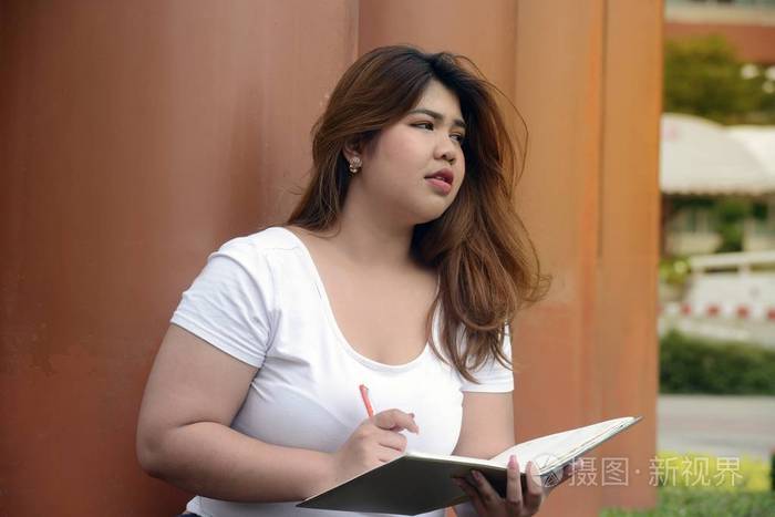 亚洲俏丽的笑脸面孔肥胖妇女公园杆群的姿态与思考