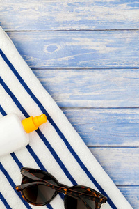 创意平躺的概念, 暑期旅游假期。海滩毛巾太阳镜海贝壳海星在柔和的蓝色木木板背景与拷贝空间样机模板为文本