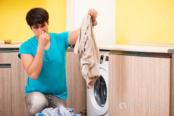 年轻的男人洗衣服在家里