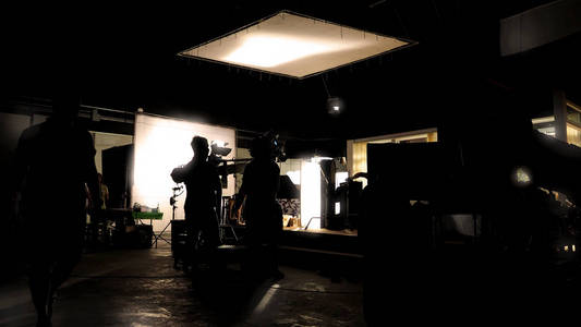 vdo 制作的低关键剪影照明幕后电影摄制组团队正在设置摄像头, 并设置拍摄和等待电影导演同意与显示器中的场景
