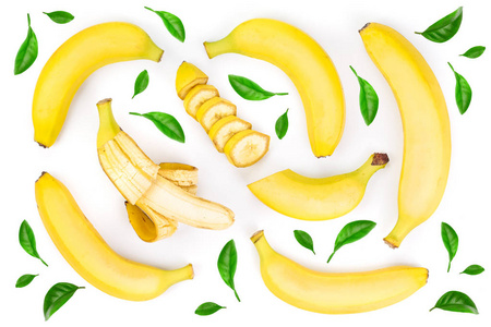 整片和切片的香蕉, 在白色背景下被隔离的绿叶点缀着。顶部视图。平躺