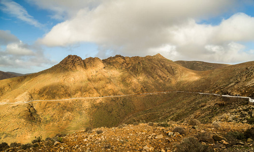 西班牙加那利群岛富埃特文图拉岛民的岩石山景观与蜿蜒的道路