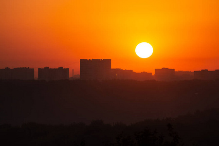 遥远建筑背景下的黎明太阳