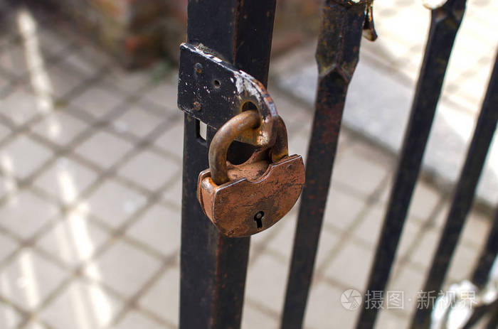 生锈的挂锁挂在金属门上
