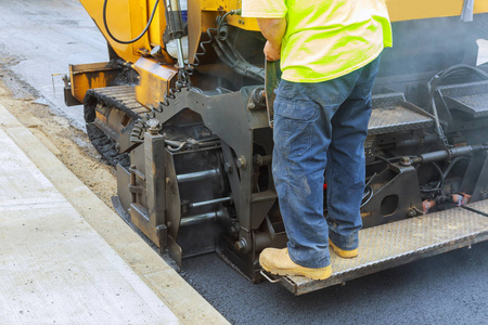 道路施工工人用铲子制造沥青铺路