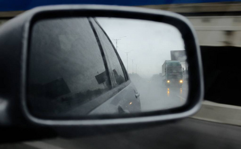 雨中道路上的汽车后视镜