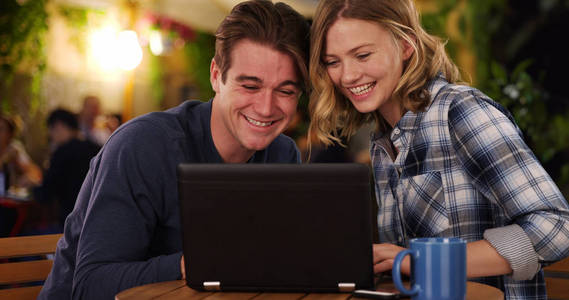 快乐的男人和女人在笔记本电脑上看视频笑着笑着