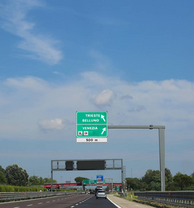 公路上的大马路标志, 前往意大利城市, 称为的里雅斯特贝卢诺或威尼斯