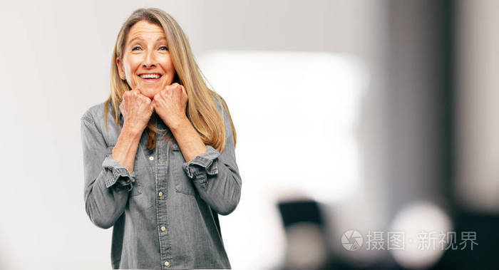 年长美丽的女人带着一个惊喜的表情, 睁大眼睛睁开宽阔的笑容, 双手