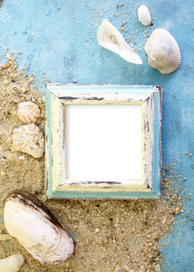 空相框与贝壳在沙滩上在蓝色的纸。旅游海滩度假的概念。文本空间