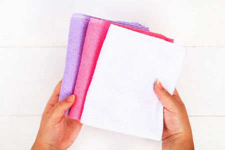 白色, 紫色和粉红色的毛巾手在白色的木桌上