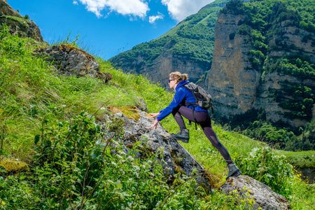 山上的女孩登山运动员。爬上山顶