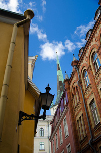 塔林老城的中世纪街道, 有五颜六色的建筑路灯和圣奥拉夫教堂塔, 爱沙尼亚