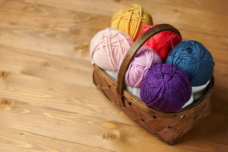 在木背景上编织的五颜六色的羊毛线