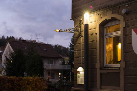 日落城市灯和历史城市的标志象老塔和十字架在德国南部秋天11月晚上在斯图加特和慕尼黑城市附近