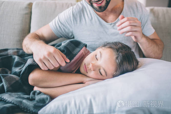 一张女孩睡觉的照片.她浑身是毯子.女孩握着她的手在头上.