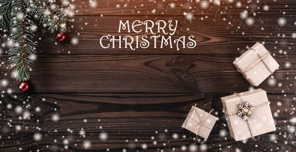 在深色木制背景的礼品盒。顶部视图。冷杉树与小球, 空间为文本。光和雪花的影响。圣诞卡