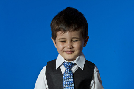 快乐的领导者，可爱的小男孩画像在蓝色色度酒泉