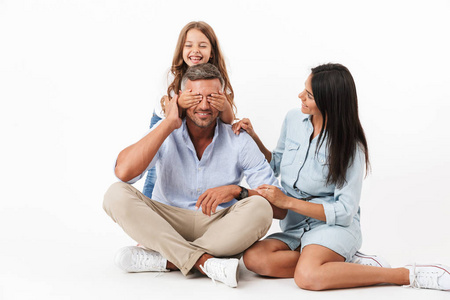 一个开朗的家庭父亲的肖像, 母亲, 小女儿在一起坐在一起孤立的灰色背景的乐趣