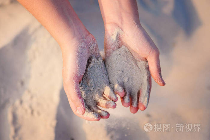 女性手把沙子倒在地上