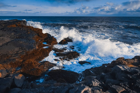蓝色海泡沫在海洋冰岛海在阳光明媚的一天殴打岩石日落