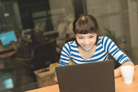 快乐的亚洲年轻女子使用笔记本电脑和感觉自由