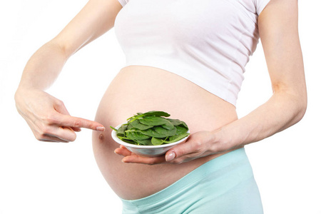 怀孕妇女显示部分绿色菠菜, 健康营养含铁和维生素的概念在怀孕期间