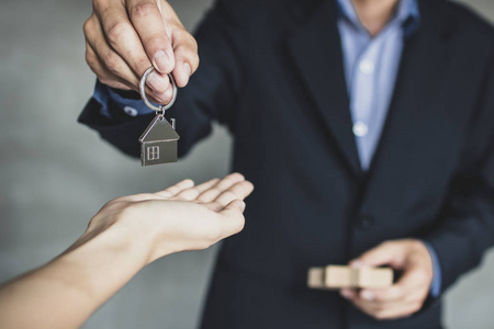 房地产经纪人, 商人或经纪人持有和手给公寓业主的新房子钥匙, 购买出售物业业务和按揭购买平面概念