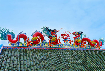 两个剪影中国龙在屋顶寺庙与蓝天