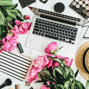 平躺时尚女性办公办公桌带笔记本电脑, 粉红色牡丹花, 化妆品, 配件。最热门的生活方式工作区夏季花卉背景