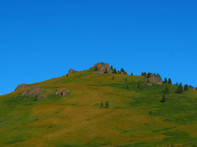 俄罗斯日落时的阿尔泰山脉天际线和绿色草坡风景如画的景色