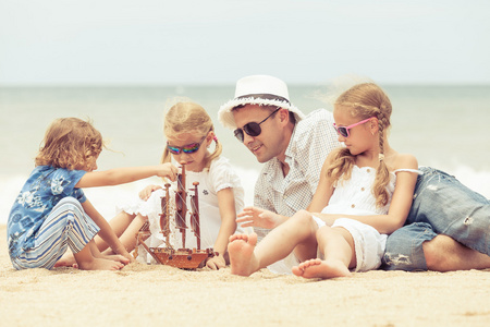 父亲和孩子们在一天时间在海滩上玩