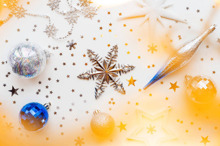 圣诞节和新年假期的背景装饰和灯泡。银色和蓝色闪亮的球, 白色的雪花和星五彩纸屑。平躺, 顶部视图