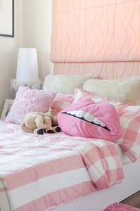 女孩的卧室在粉红色的颜色与枕头和娃娃