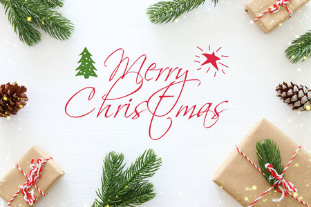 圣诞节背景与松果, 冷杉分枝和礼物在木白色背景。平面布局, 顶部视图