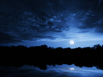 深蓝色的天空湖面倒影与云的戏剧性月亮升起