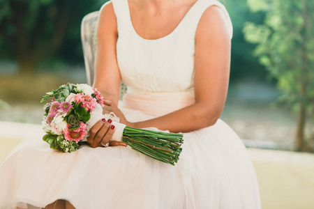 新娘在她的大腿上捧着她的花束在她的婚礼
