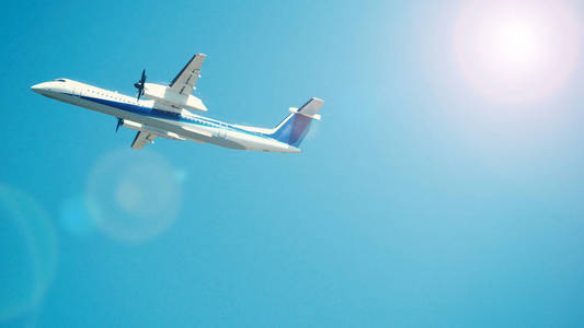 飞机起飞到蓝天从札幌北海道日本的国际机场跑道, 有太阳光耀斑相机和拍摄从 uprisen 或低角度视图