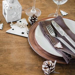 简单的圣诞餐桌的地方设置在木制背景的复古或乡村风格。为圣诞节或新年晚餐准备的节日餐桌