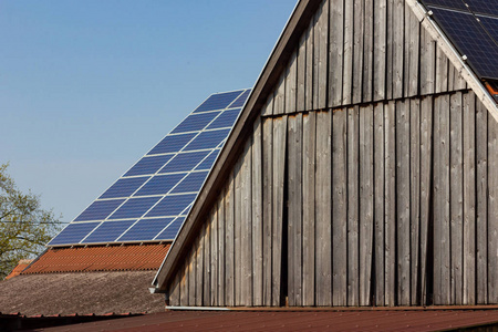 屋顶上的太阳能电池板在蓝天晴朗的春天天的木幕墙