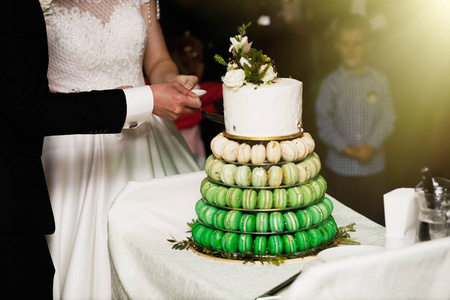 优雅漂亮的年轻新娘和新郎切婚礼蛋糕