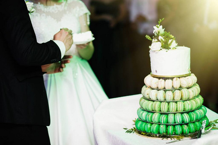 优雅漂亮的年轻新娘和新郎切婚礼蛋糕
